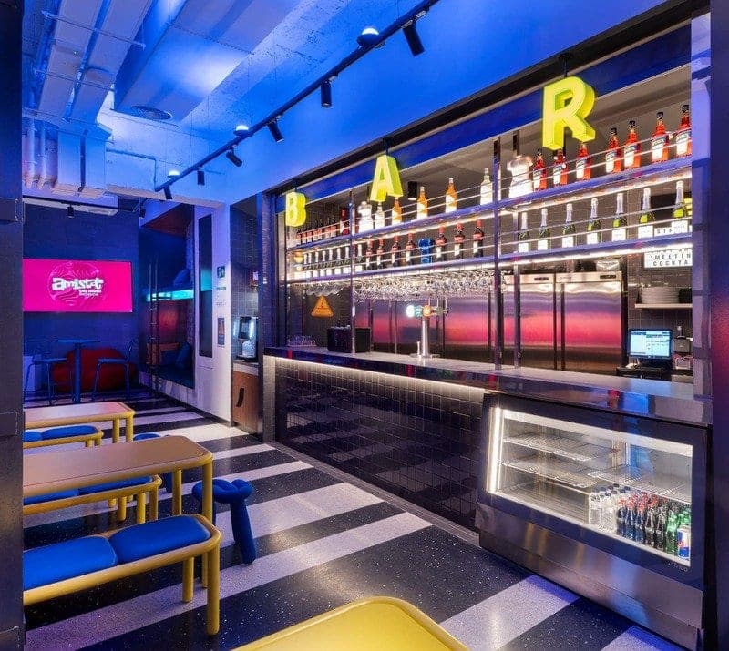 Hostel bar under blue lighting with lit letters