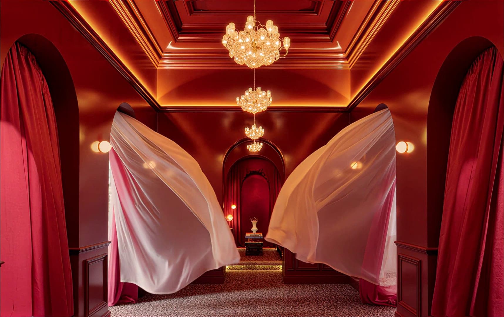 Crimson room with chandeliers and billowing fabric