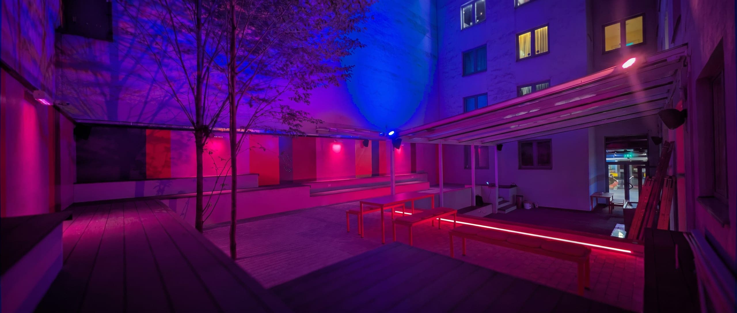 Courtyard terrace under night lighting, wide view