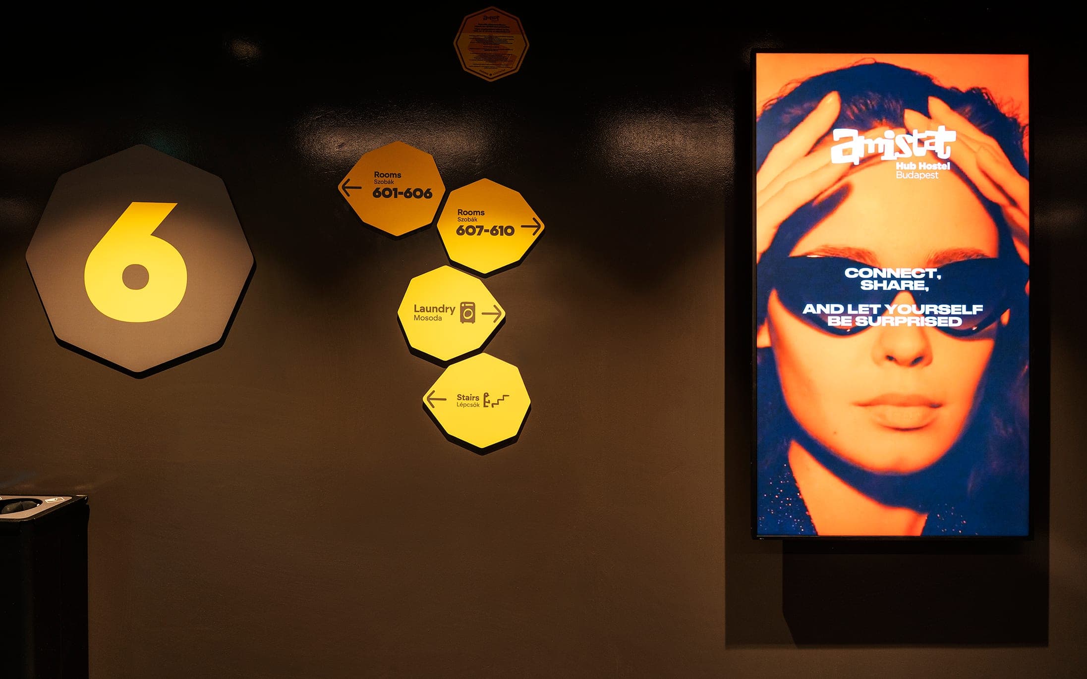 Floor six wayfinding signs next to a digital signage screen